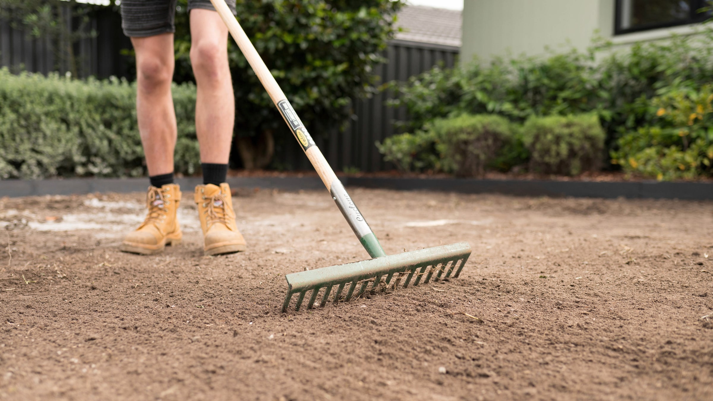 Soil being levelled with a landscape rake before turf installation