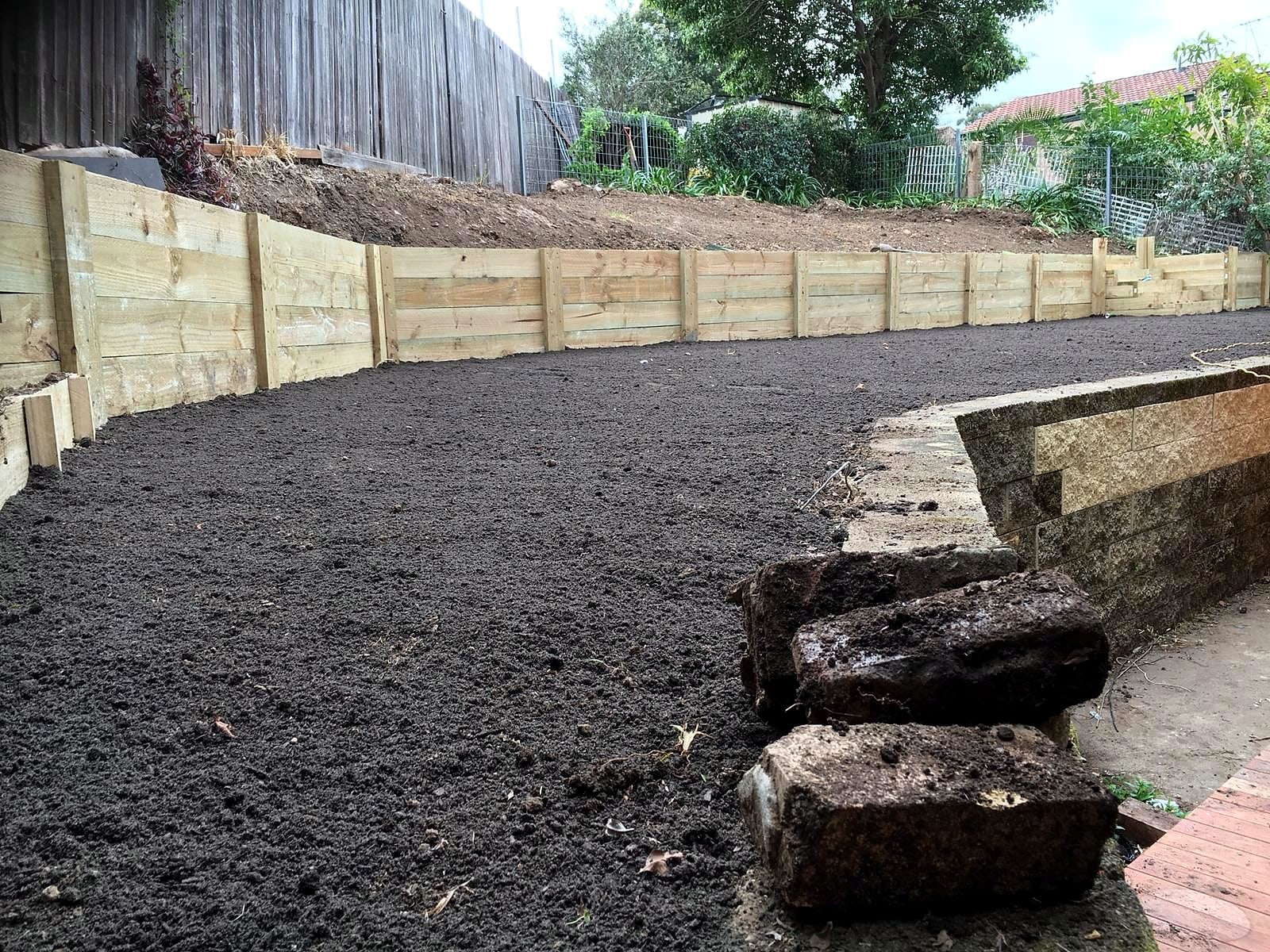 Prepared soil levelled behind the timber sleeper edge in Ermington